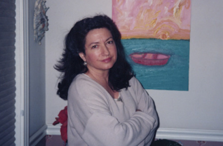 Poet Susan Kelly Dewitt standing with her arms crossed in front of a painting.